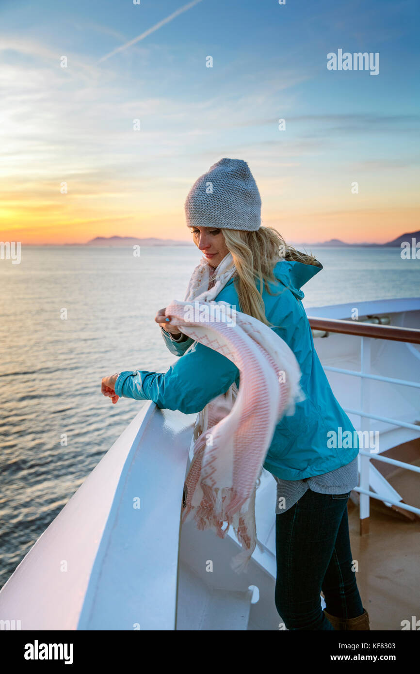 Canada Vancouver, British Columbia, passeggero femmina godendo la vista al tramonto del passaggio di scoperta nel passaggio interno, Holland America cruise Foto Stock