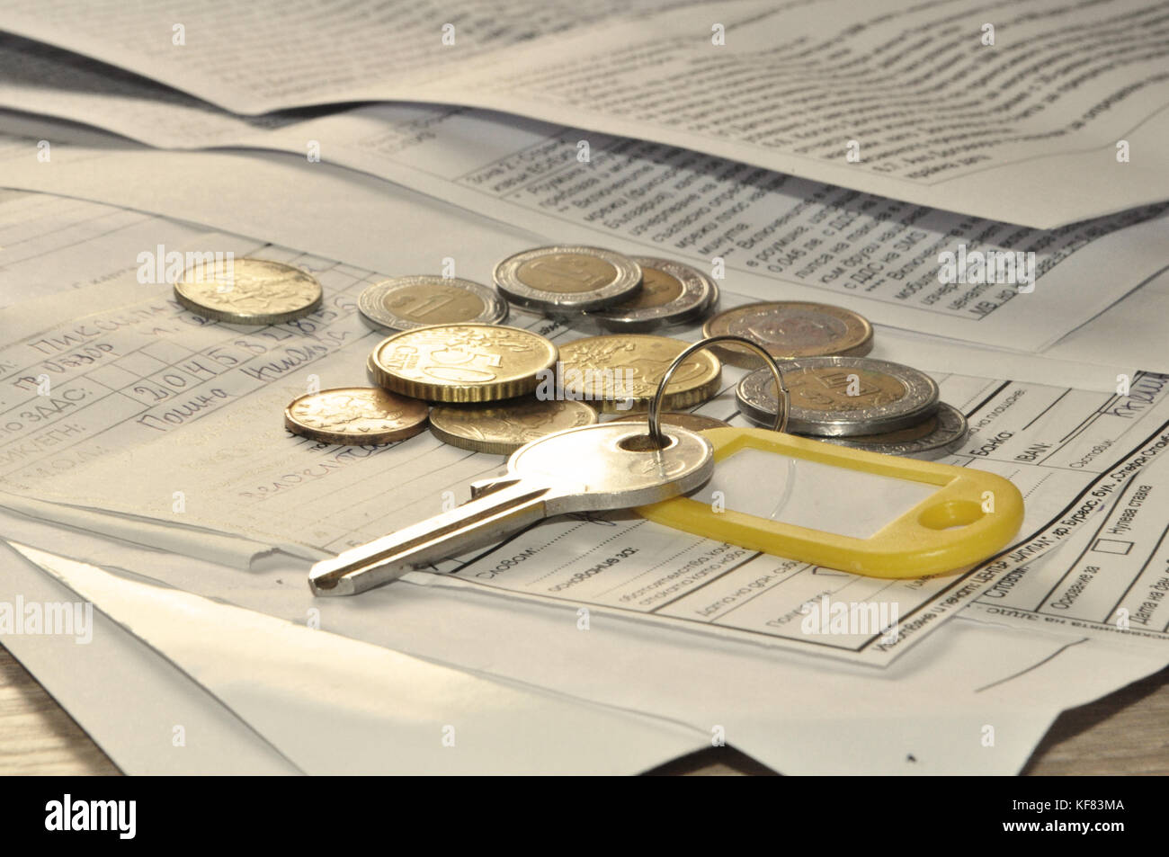 Un titolare di chiave e monete su una pila di documenti/ Proprietà/ acquisto di proprietà di assicurazione Foto Stock