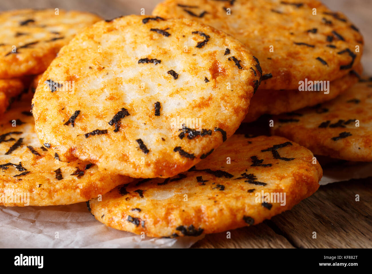Giapponese snack croccante torte di riso con alghe marine e tapioca macro sul tavolo orizzontale. Foto Stock