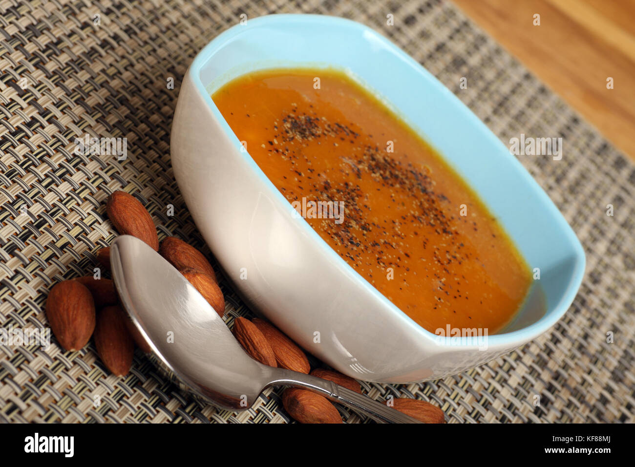 Fresca zuppa fatta in casa, arrosti di zucca con pepe nero. una manciata di mandorle per completare il pasto sano. Foto Stock