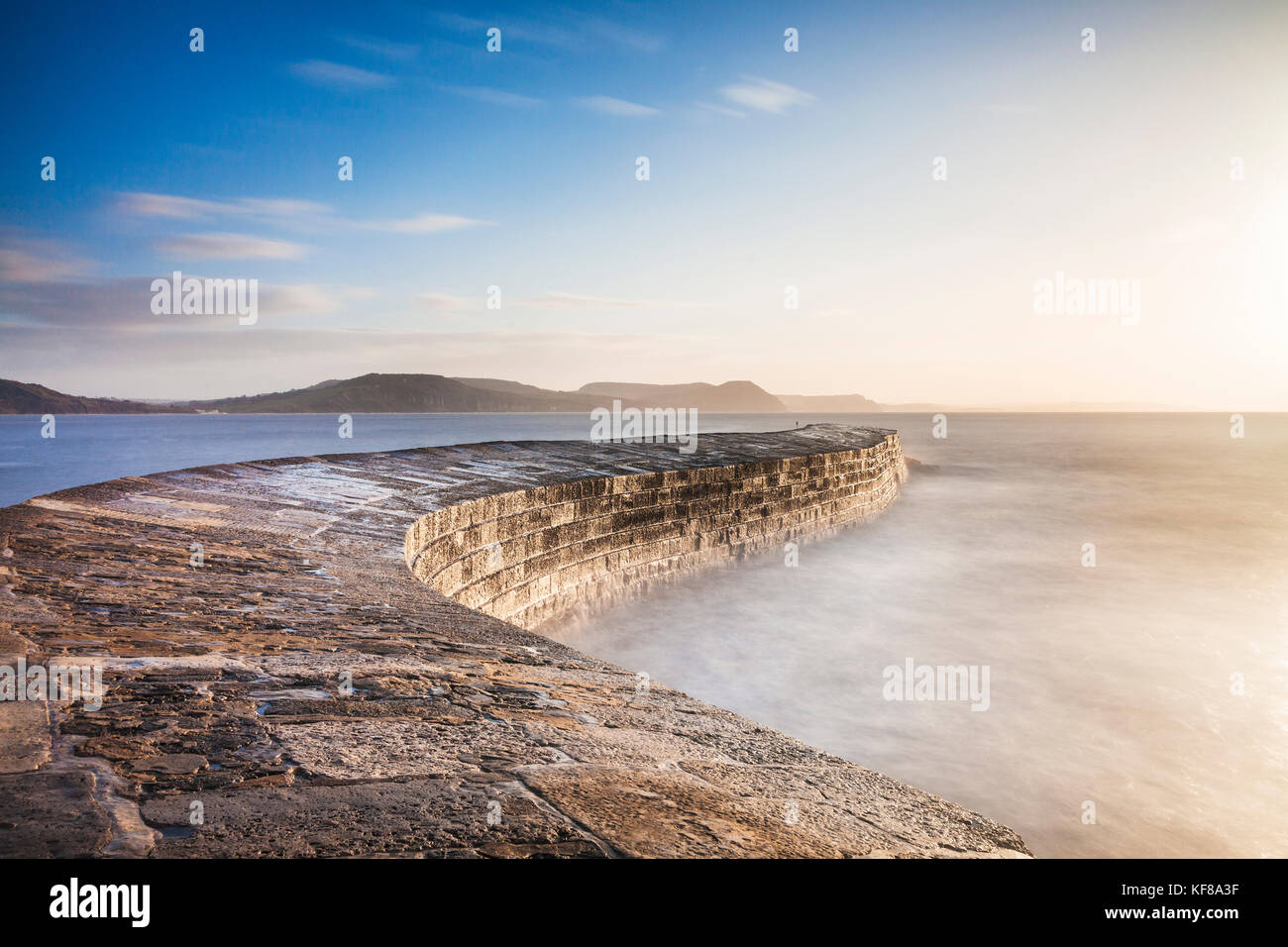 Sunrise oltre il Cobb a Lyme Regis nel Dorset. Foto Stock