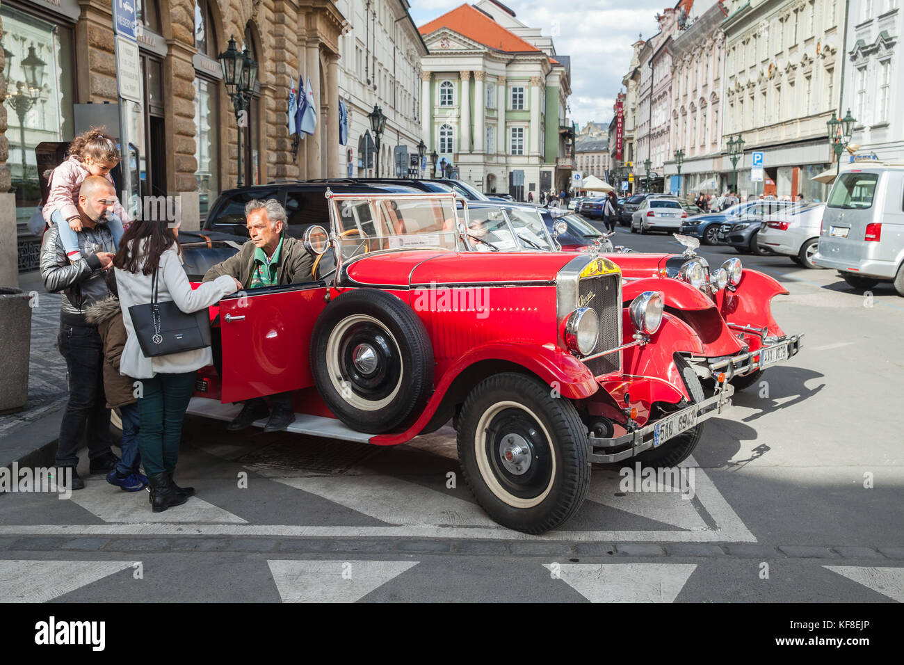 Praga, Repubblica Ceca - 2 maggio 2017: turisti parlare con driver di Red oldtimer auto sulla strada della vecchia Praga Foto Stock