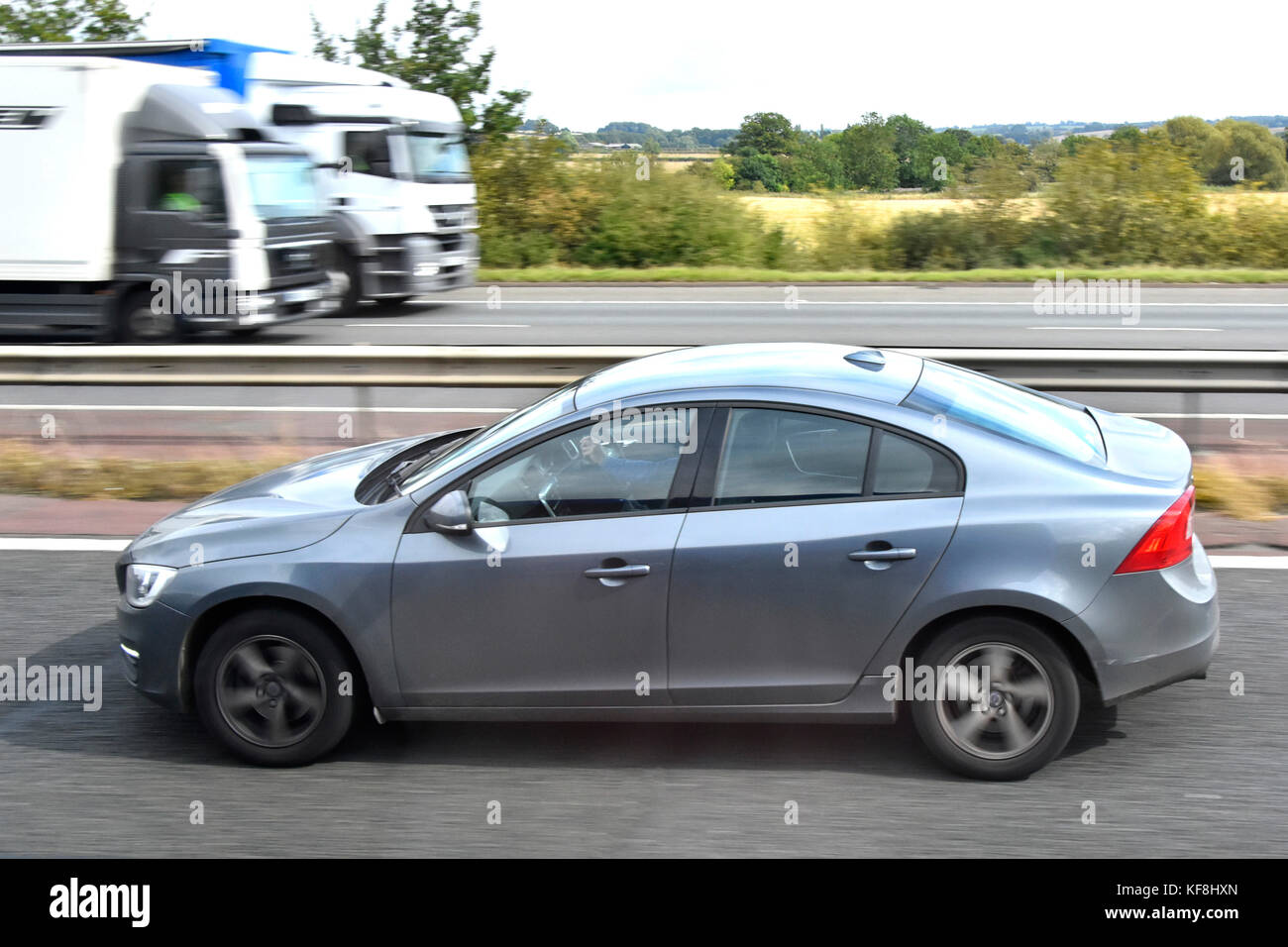 Close up di automobile che viaggia a velocità lungo l autostrada M40 con motion blur autocarri e camion che viaggiano nella direzione opposta England Regno Unito Foto Stock