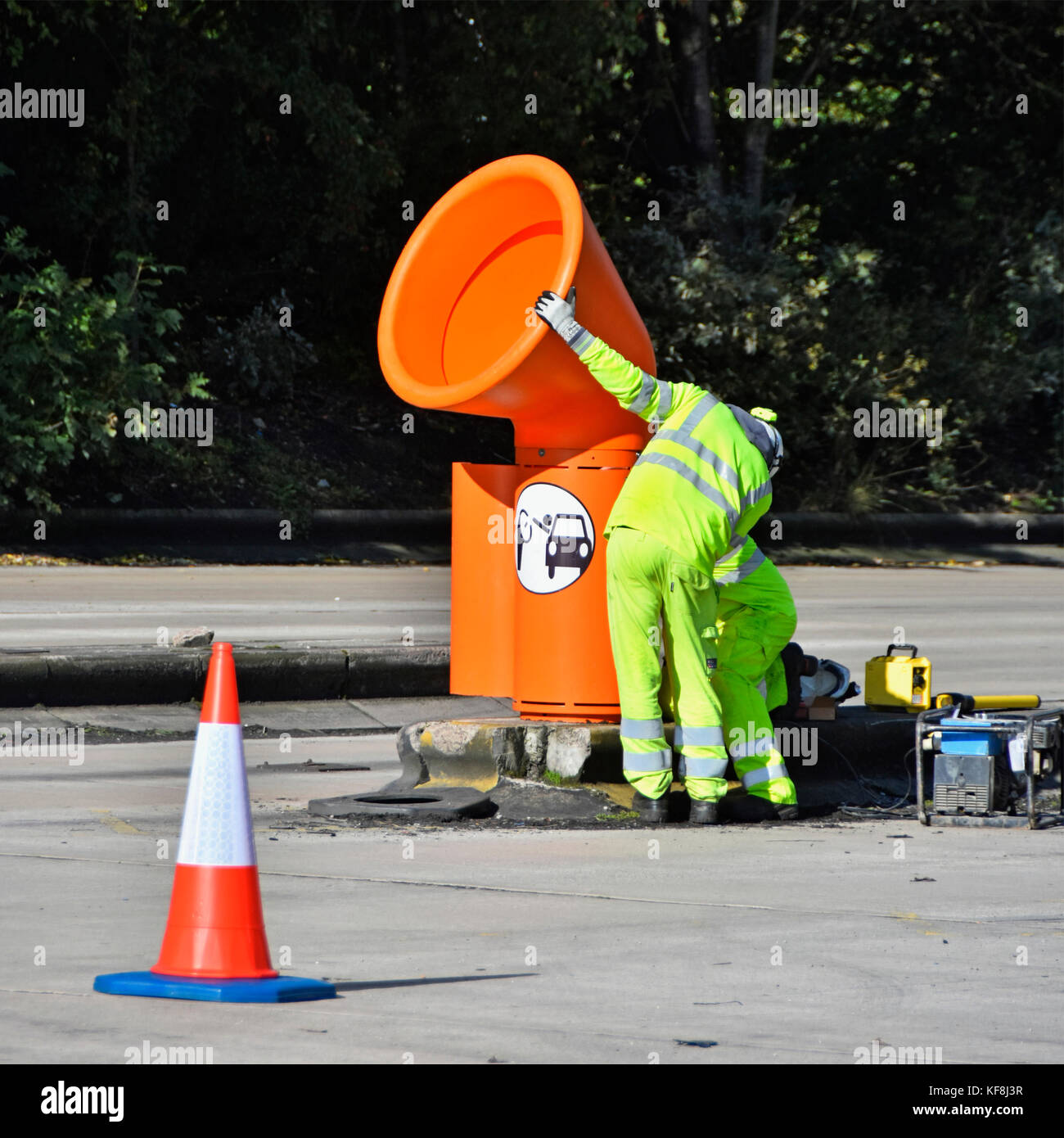Operai installazione orange alta livello cestini per uso da parte di entrambi i camion e i conducenti di auto uscire Lymm M6 Motorway Services nel Cheshire England Regno Unito Foto Stock