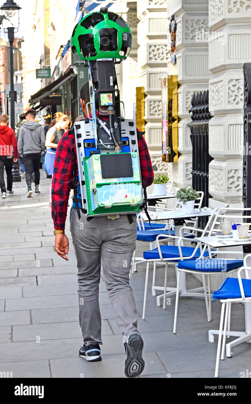 Man Walking Pavement Londra West End Inghilterra UK con Google zaino trekker per fotocamera fissato al corpo usato per fare scene di street view sulla mappa di pegman Foto Stock