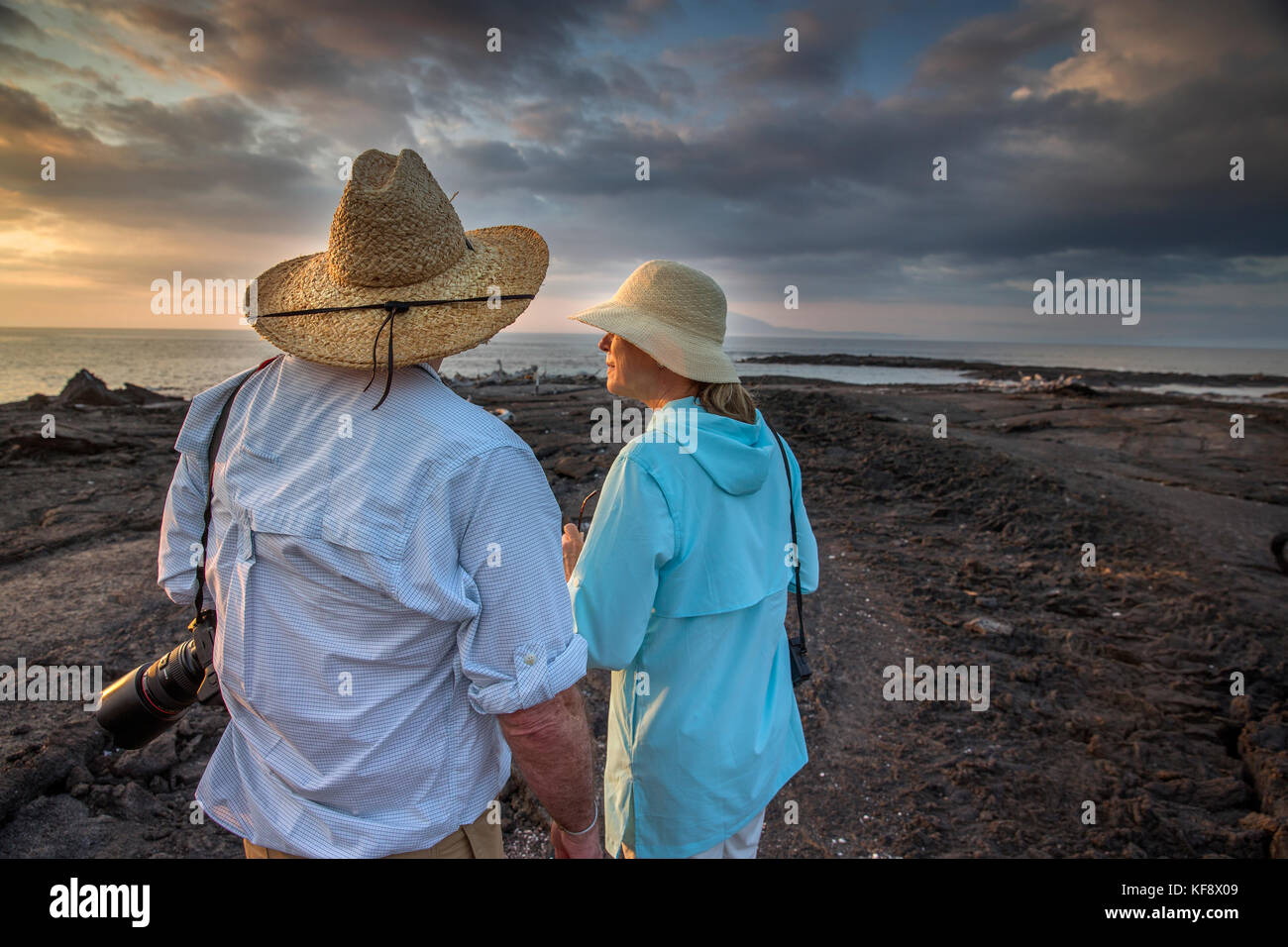 Isole Galapagos, ecuador, individui appendere fuori sulla spiaggia e guardare il tramonto dal Fernandina Island Foto Stock