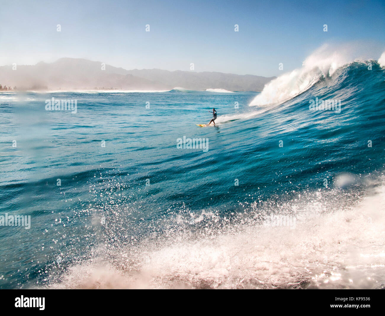 Donna rimorchiare il surf sulla sponda nord delle Hawaii Foto Stock