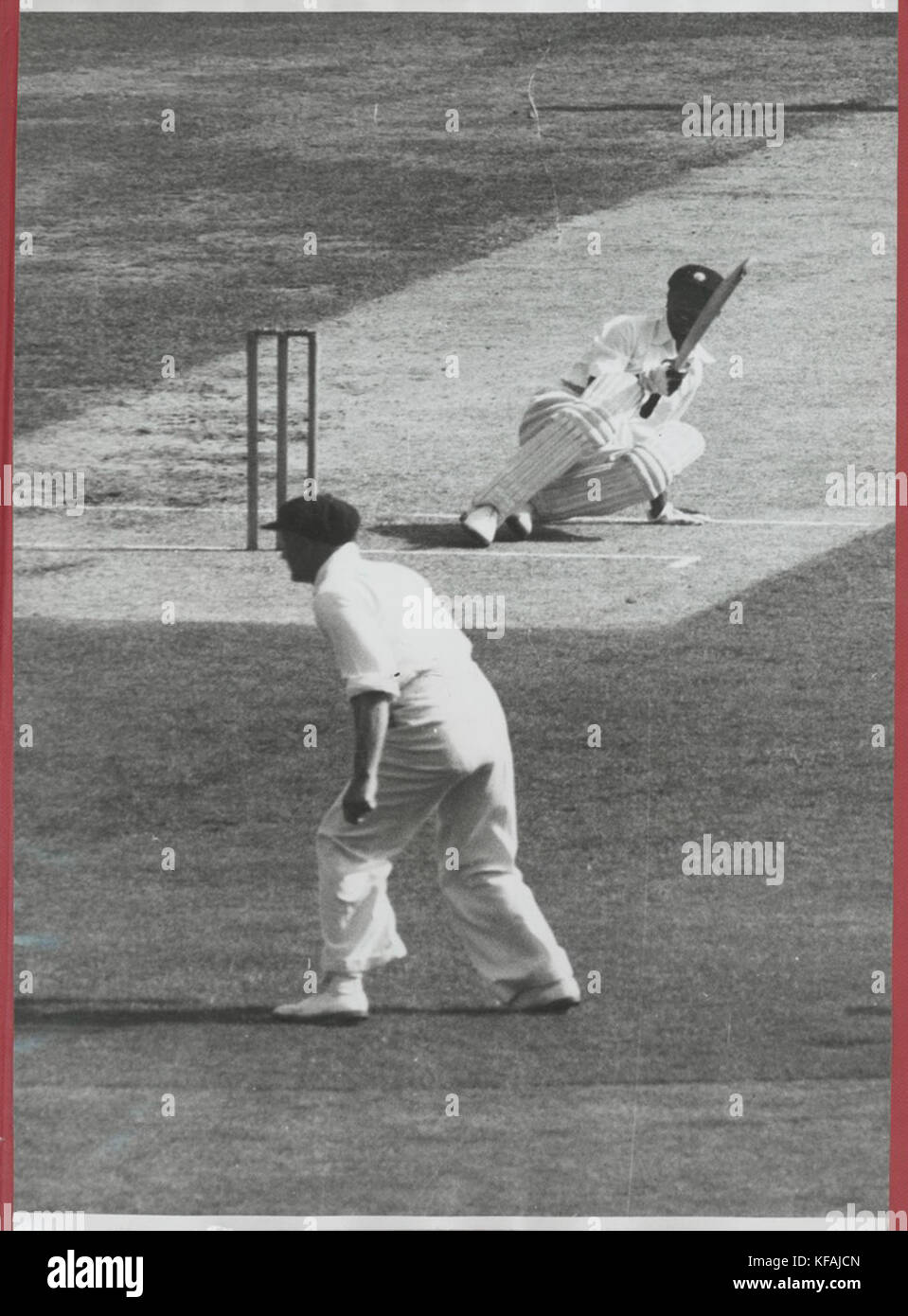 Un tiro d'azione che mostra Phadkar scivolare sul campo mentre tenta di agganciare una palla corta da W. Johnston durante una partita di cricket. Il momento cattura le dinamiche del gioco. Foto Stock