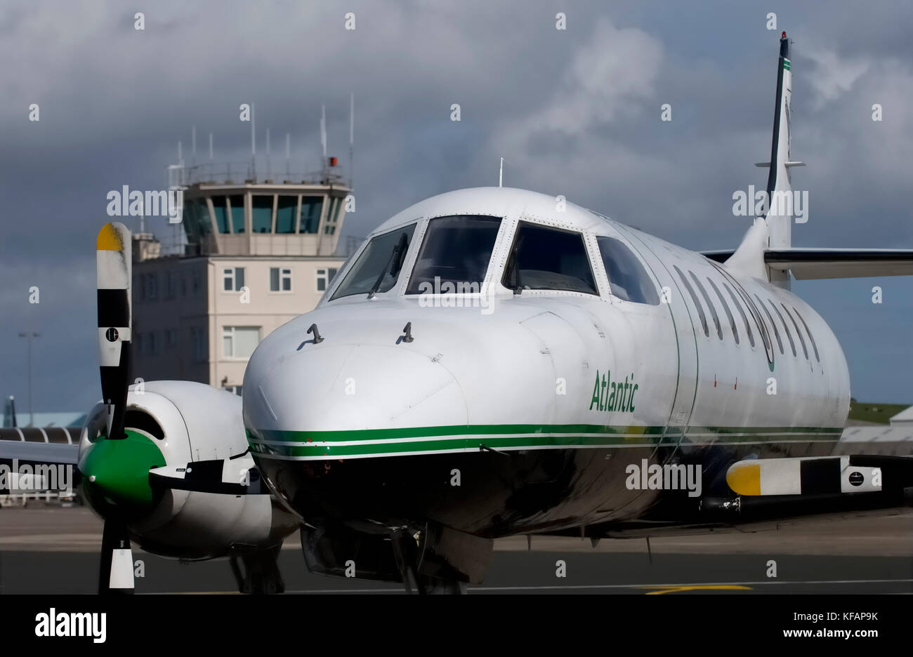 Un Atlantic Airlines Fairchild SA-227AC Metro III / 3 parcheggiato con il sistema di controllo del traffico aereo a torre dietro Foto Stock