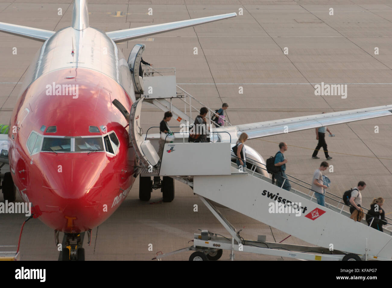 I passeggeri con bagaglio a mano borse di sbarco da Swissport airstairs dal Norwegian  Air Shuttle Boeing 737-300 Foto stock - Alamy