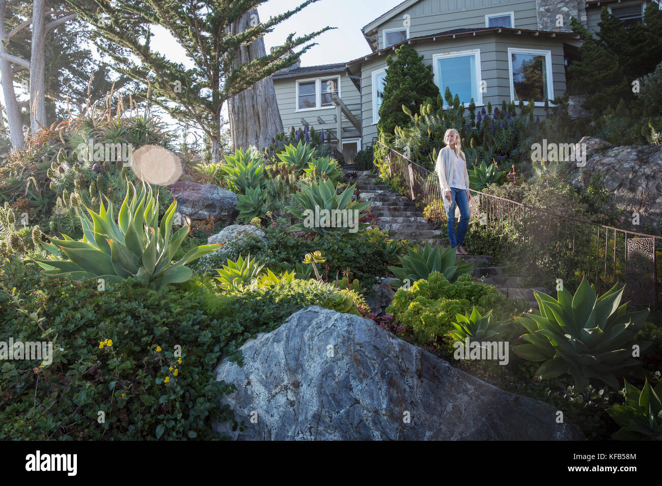 Stati Uniti, California, Big Sur, esalen, una donna cammina giù per le scale che portano al ponte sottostante la casa di Murphy, il Esalen Institute Foto Stock