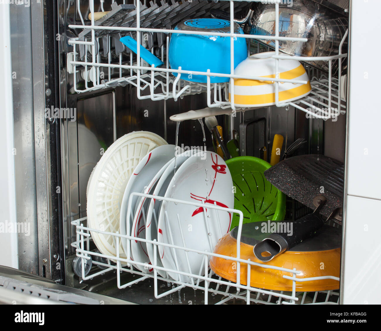 I piatti sporchi caricato in una macchina lavastoviglie con porta anteriore aperta. Foto Stock
