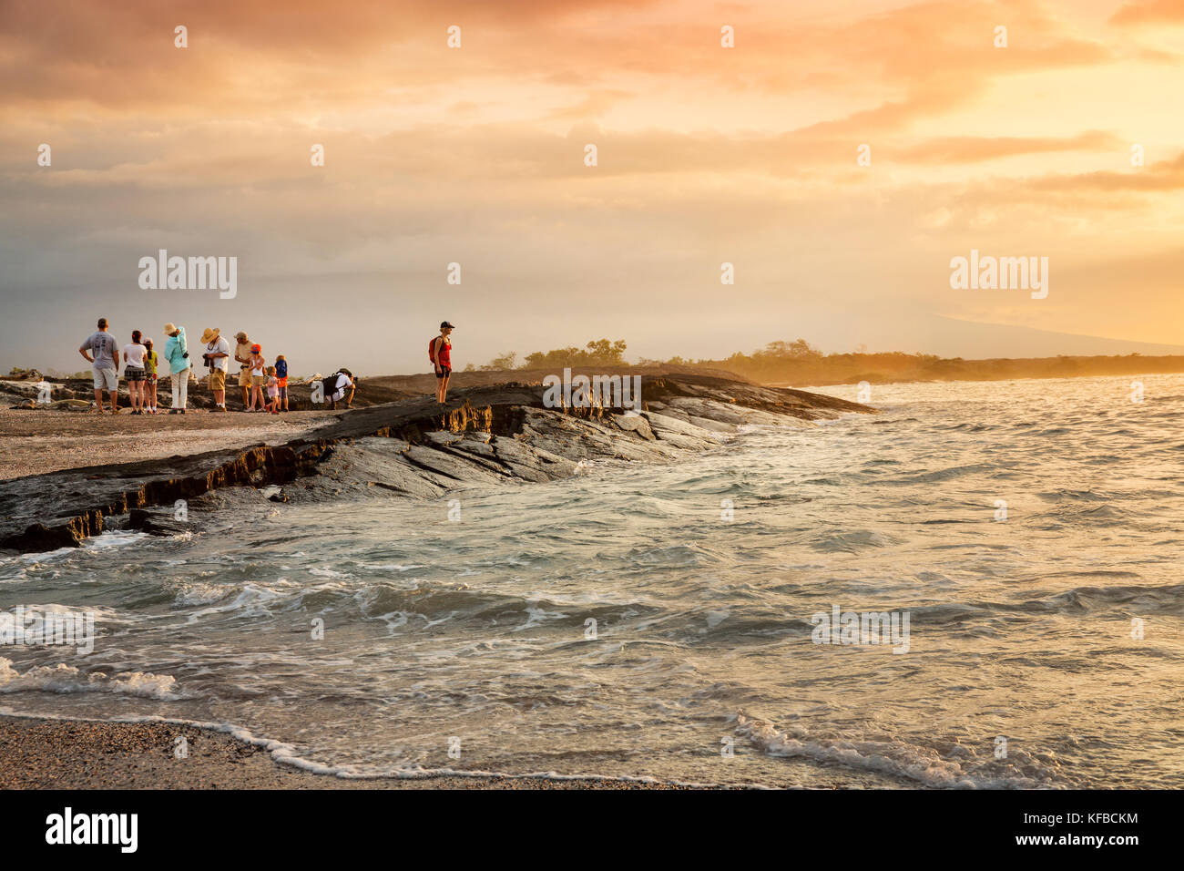 Isole GALAPAGOS, ECUADOR, un gruppo di persone appendere fuori sulla spiaggia e guardare il tramonto dal Fernandina Island Foto Stock
