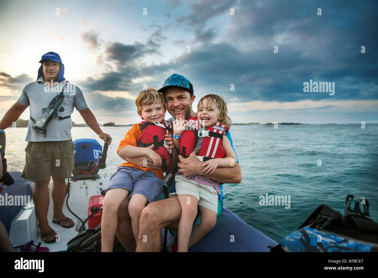 Isole GALAPAGOS, ECUADOR, il padre con il figlio e la figlia di viaggio in un zodiac come essi lasciare Fernandina Island Foto Stock