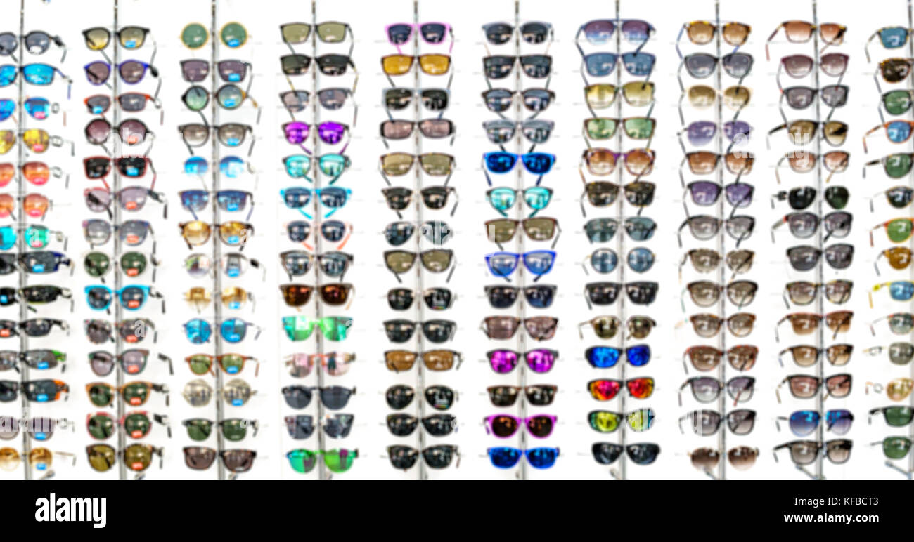 Vista offuscata della parete con molti occhiali da sole Foto Stock