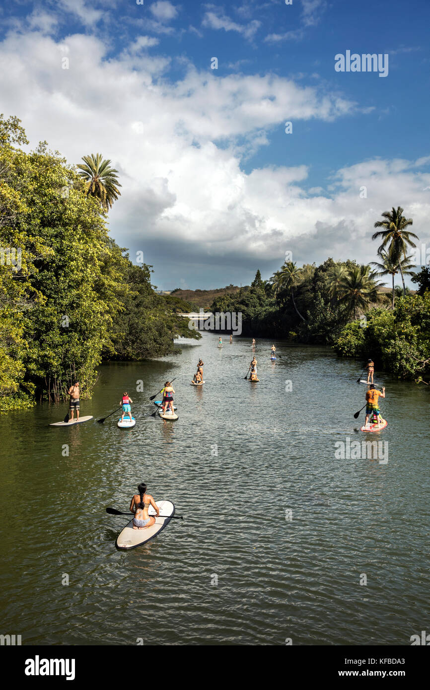 HAWAII, Oahu, North Shore, viaggiatori paddleboarding sul fiume Anahulu sotto lo storico Ponte di Arcobaleno nella città di Haliewa Foto Stock