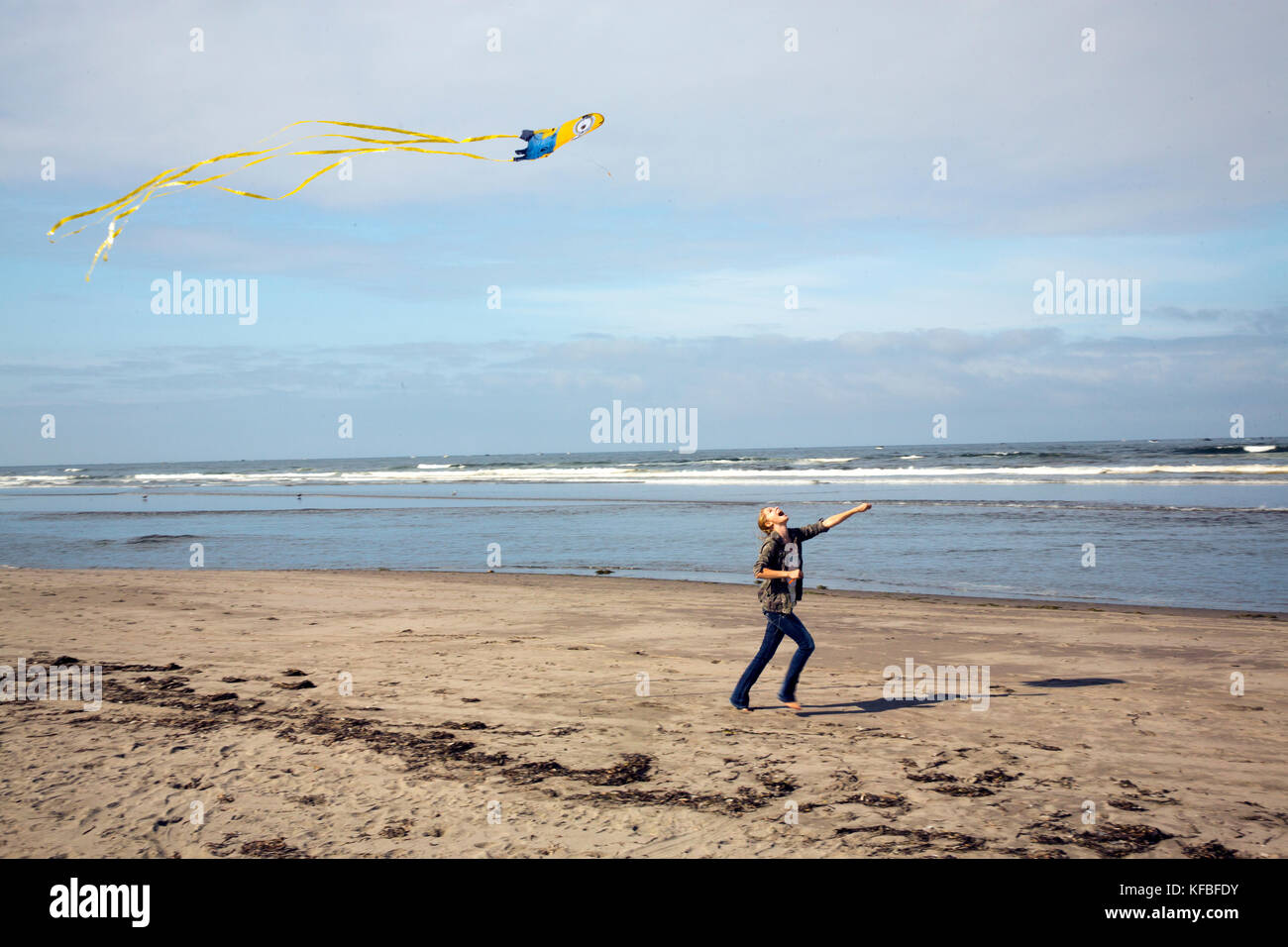 Stati Uniti d'America, nello stato di Washington, spiaggia lunga penisola, international kite festival, giovane donna corre sulla spiaggia con il suo kite Foto Stock