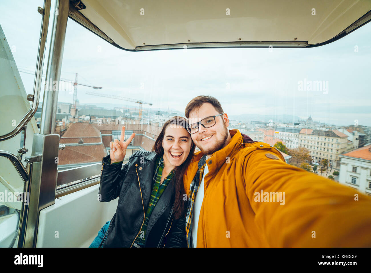 L'uomo con la donna a ruota panoramica Ferris prendendo un selfie Foto Stock