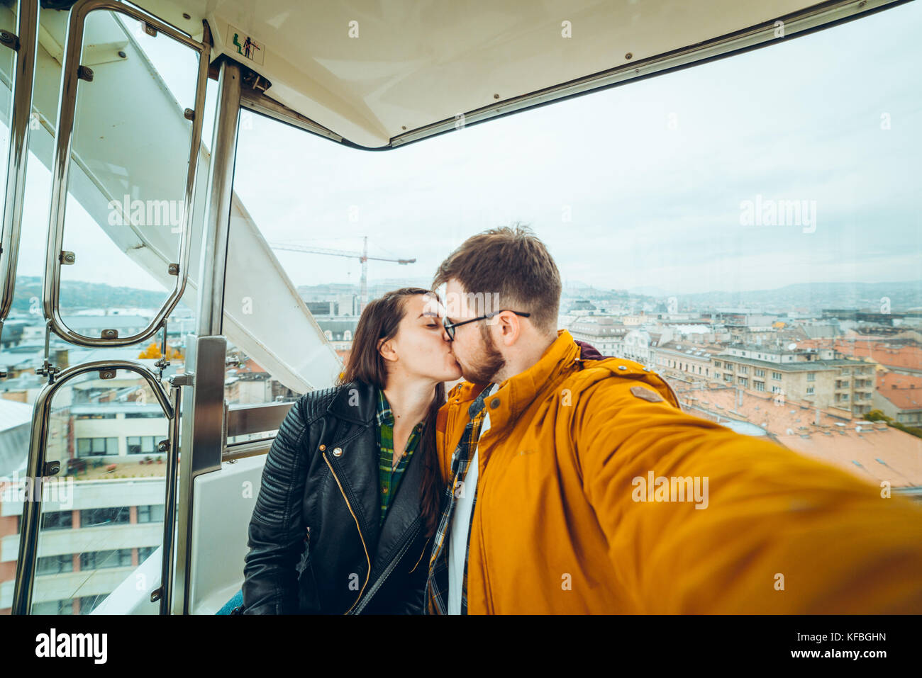 L'uomo con la donna a ruota panoramica Ferris prendendo un selfie Foto Stock