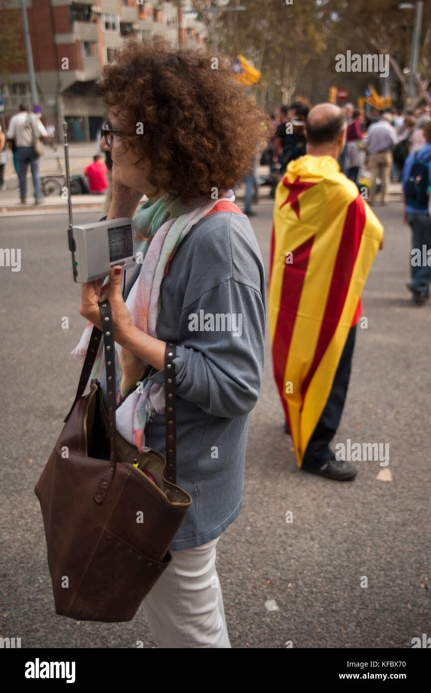 Barcellona, Spagna. 27 Ott 2017. Una donna alle porte del parlamento della Catalogna ascolta la radio al voto degli emendamenti per proclamare l'indipendenza. Credit: Charlie Perez/Alamy Live News Foto Stock