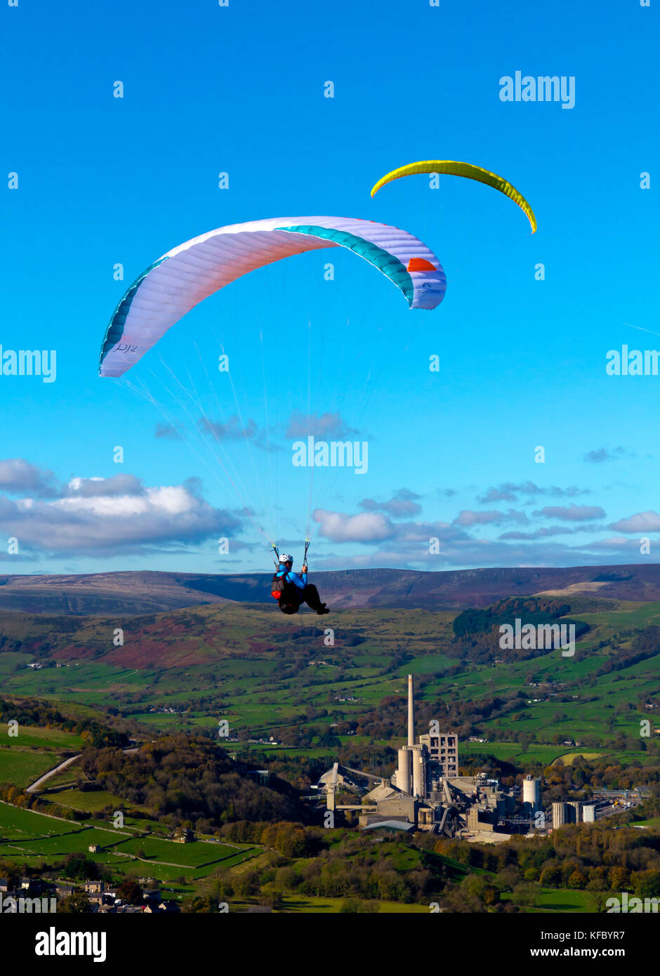 I parapendii sorvolano Bradwell bordo nel Parco Nazionale di Peak District DERBYSHIRE REGNO UNITO Inghilterra con speranza opere in cemento visibili al di sotto Foto Stock