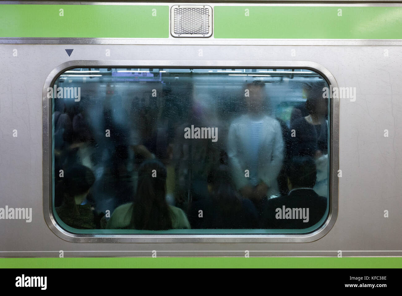 I pendolari si sono visti attraverso una finestra nebulizzata e appannata di un treno della linea Yamanote, la stazione di Shinjuku, Tokyo, Giappone. Foto Stock