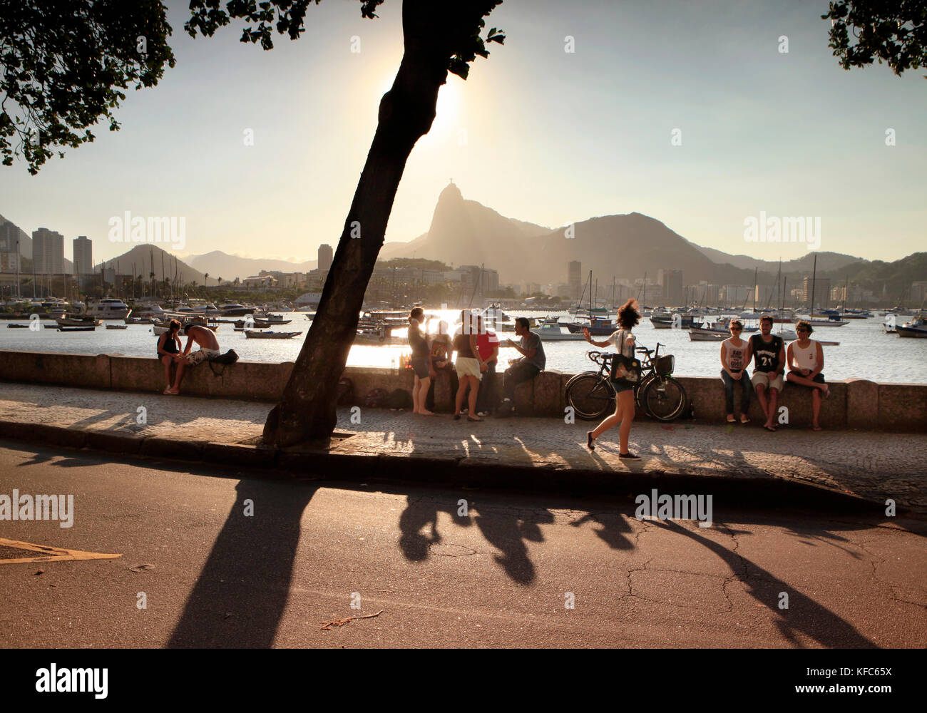 Il Brasile, Rio de Janeiro, Bar Urca, persone a sedersi su una parete del mare sull'Oceano Atlantico Foto Stock
