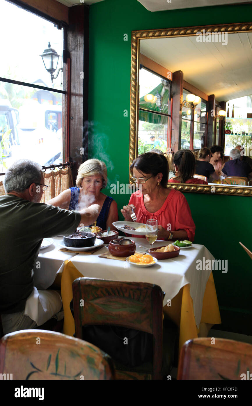 Il Brasile, Rio de Janeiro, tre individui godetevi il pranzo nella Casa de Feijoada Foto Stock