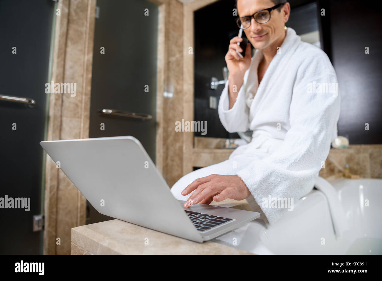Imprenditore in accappatoio utilizzando laptop Foto Stock