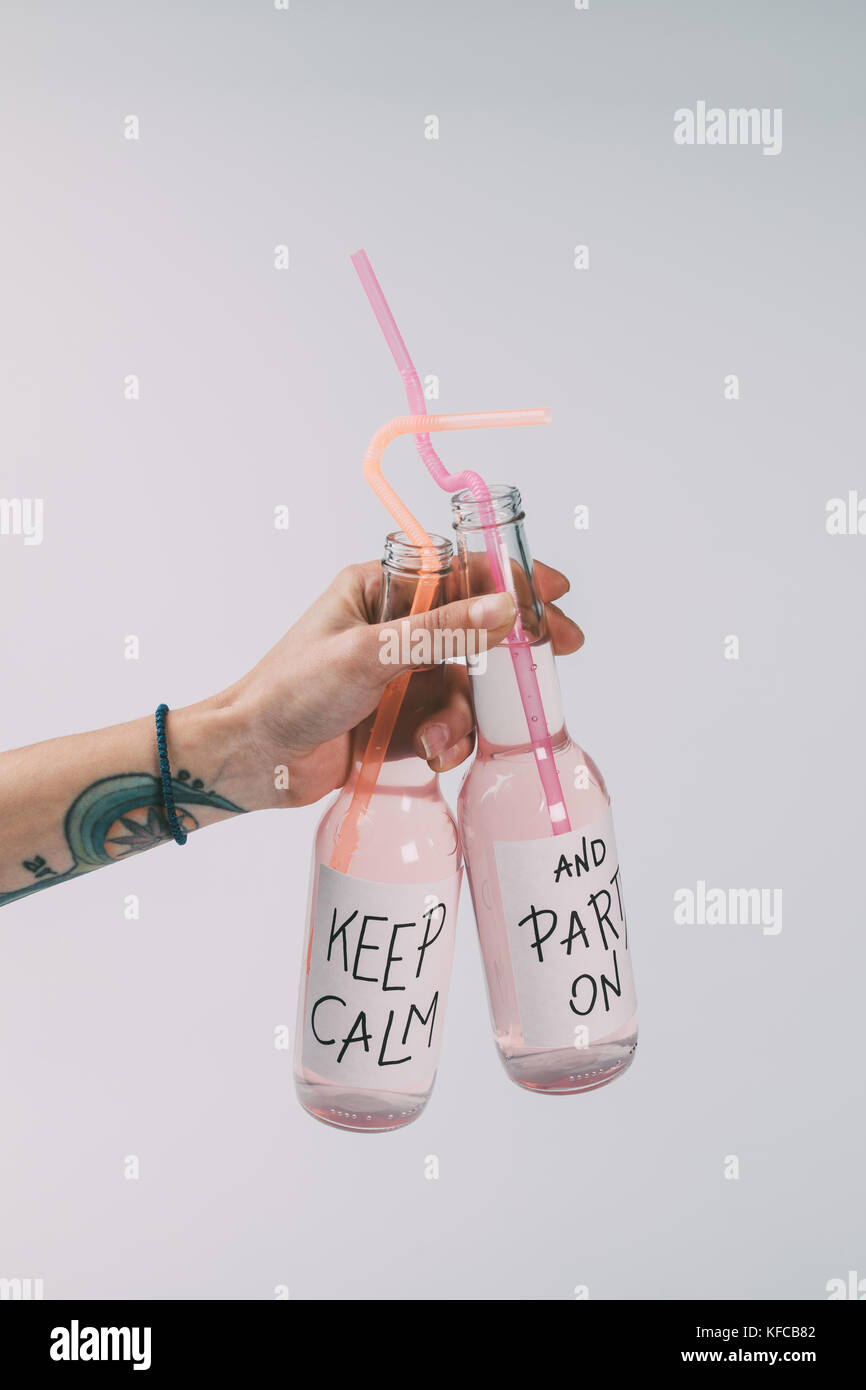 Bottiglie di bevande alcoliche in mano Foto Stock