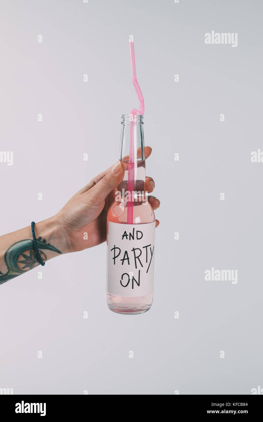 Bottiglia di bevande alcoliche in mano Foto Stock