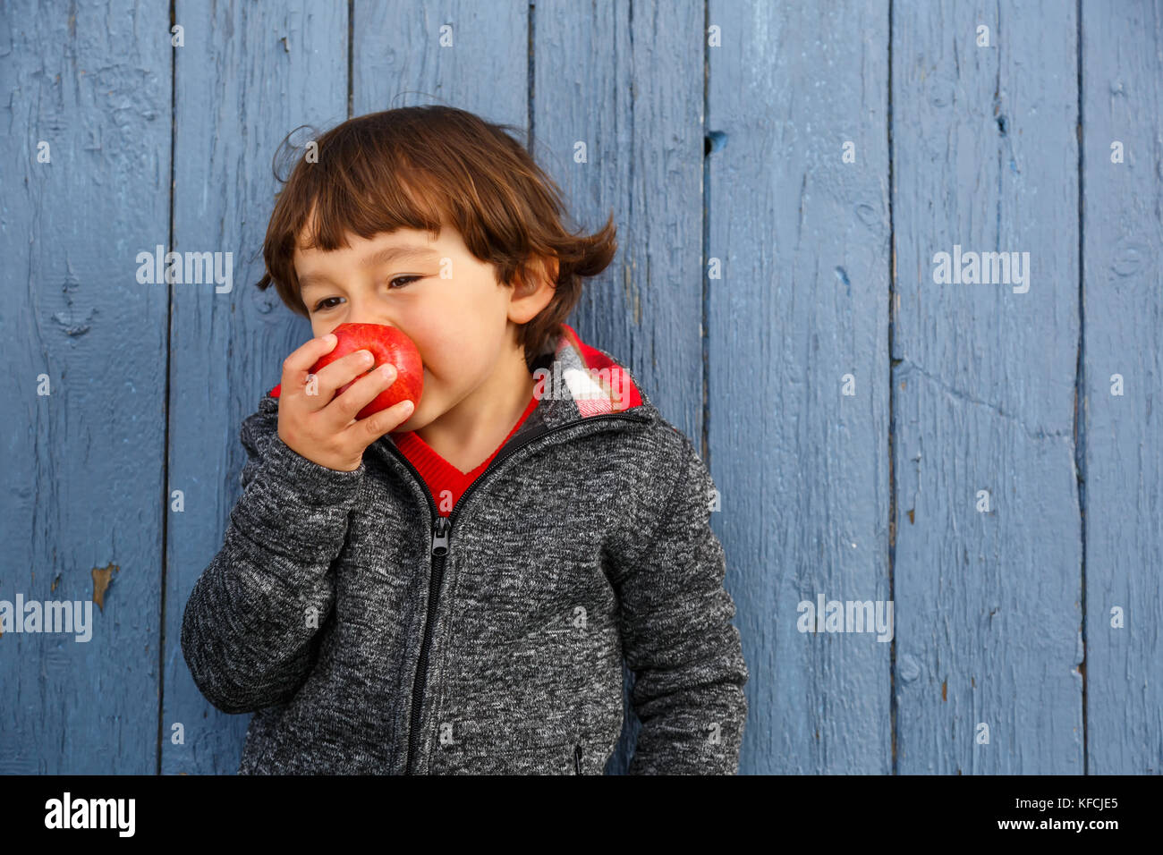 Bambino kid mangiare frutta Apple sorridenti autunno cadono all'esterno sano Foto Stock