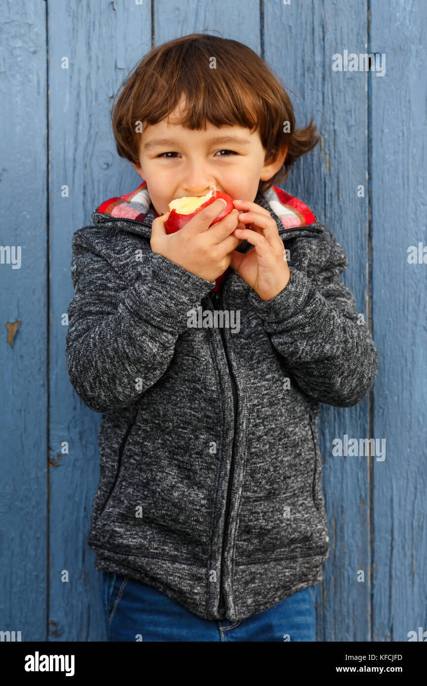 Bambino kid mangiare frutta apple formato ritratto outdoor autunno cadono all'esterno sano Foto Stock