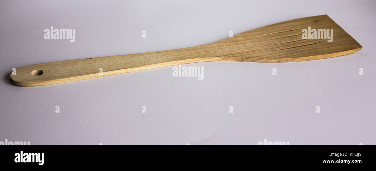 Spatola di legno su sfondo bianco con ombre spatola in legno per il teflon ware Foto Stock