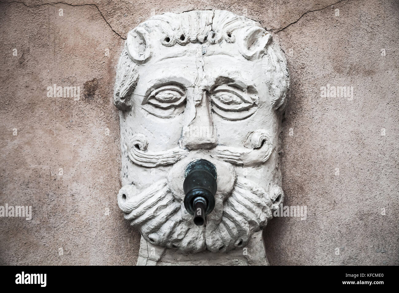Antica fontana con acqua potabile nella forma di un barbuto viso maschile. fermo, Italia Foto Stock