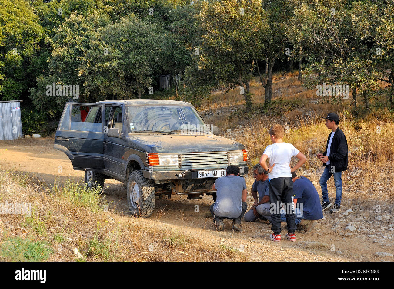 La riparazione di un problema meccanico su un off-road auto su una corsa di prova Foto Stock