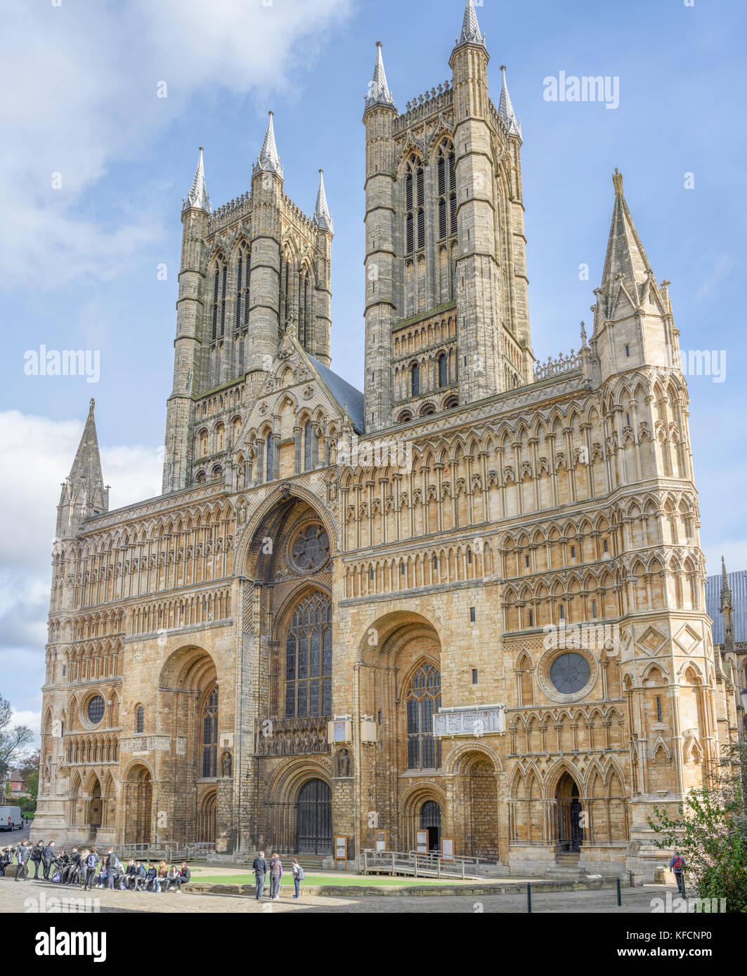 Visitatori presso la facciata occidentale della cattedrale medievale a Lincoln, Inghilterra. Foto Stock