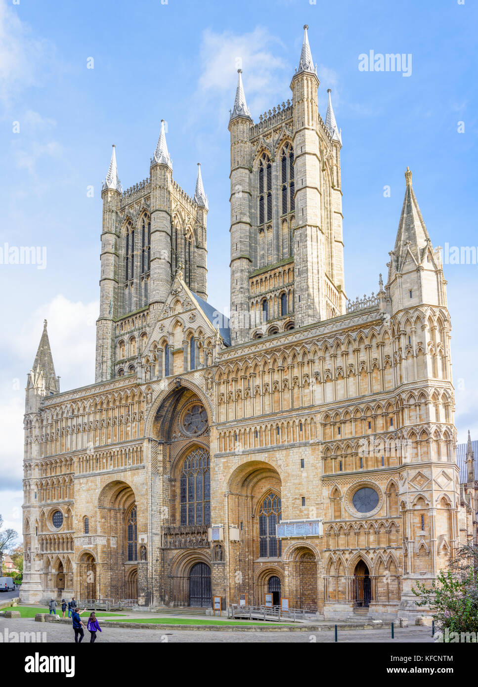Visitatori presso la facciata occidentale della cattedrale medievale a Lincoln, Inghilterra. Foto Stock