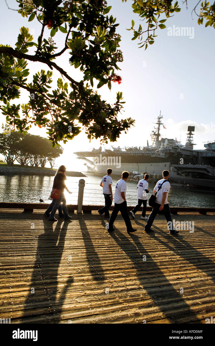 Stati Uniti, California, San Diego, un gruppo di individui a piedi lungo la baia di San Diego verso la USS Midway Museum Foto Stock