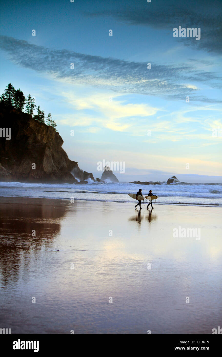 Stati Uniti d'America, oregon, Oswald west state park, surfisti a piedi lungo la spiaggia e fuori nell'acqua a oswald state park, appena a sud di Cannon Beach Foto Stock