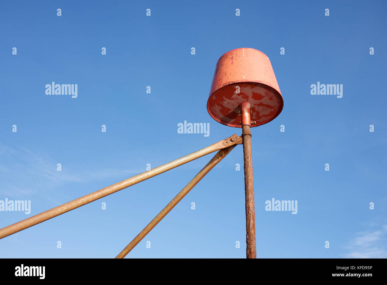 Un oggetto arancione su di un telaio metallico contro un cielo blu Foto Stock