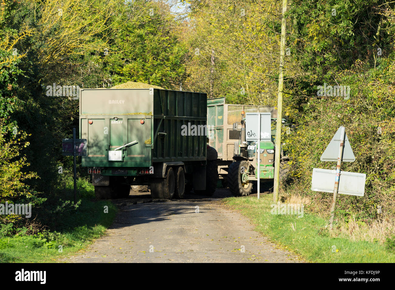 I trattori agricoli e i rimorchi cercando di passare sulla stretta corsia di paese Foto Stock