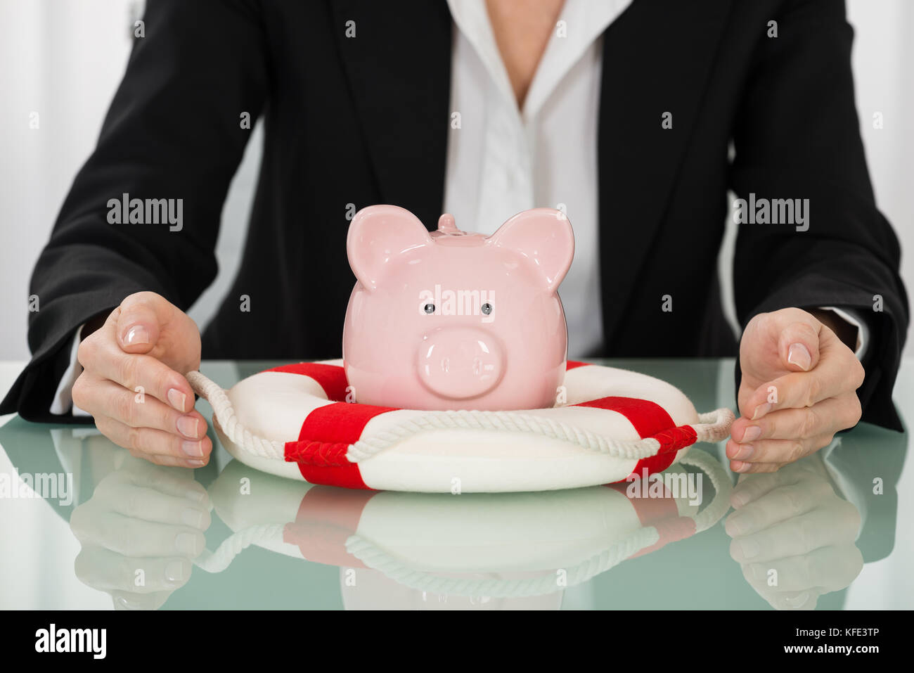 Close-up di imprenditrice proteggere piggybank con lifebelt Foto Stock