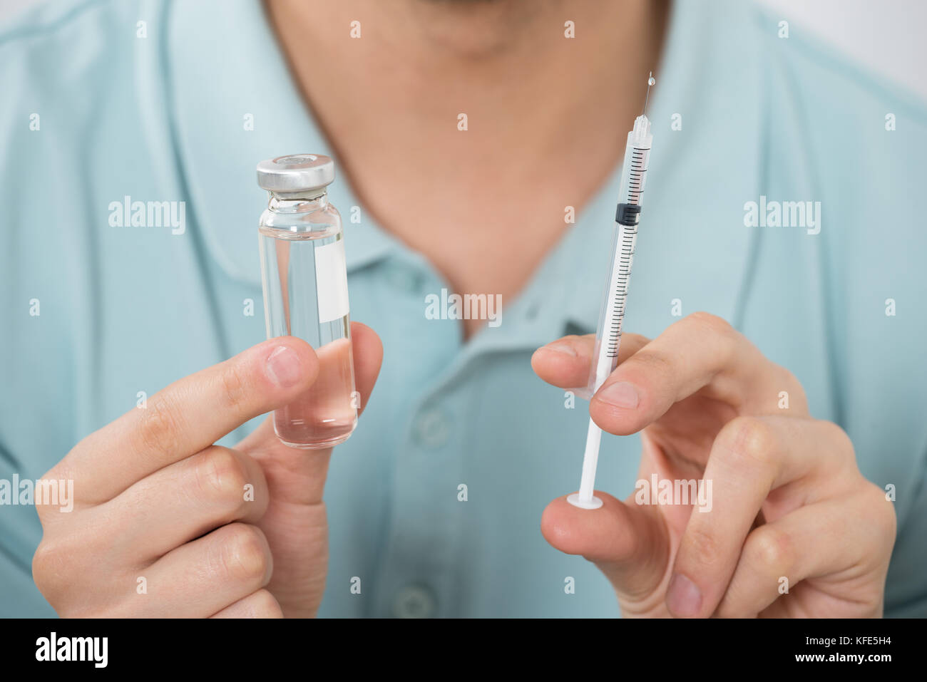 Close-up del giovane azienda Medicina bottiglia e siringa Foto Stock