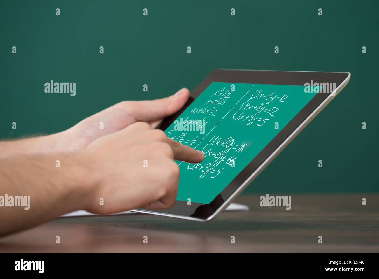 Close-up di apprendimento uomo equazioni matematiche sulla tavoletta digitale in aula Foto Stock