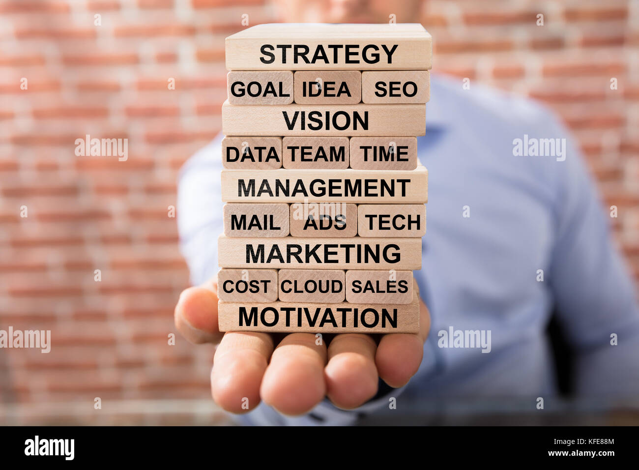 Close-up di un imprenditore tenendo pila di business dei blocchi di legno in mano Foto Stock