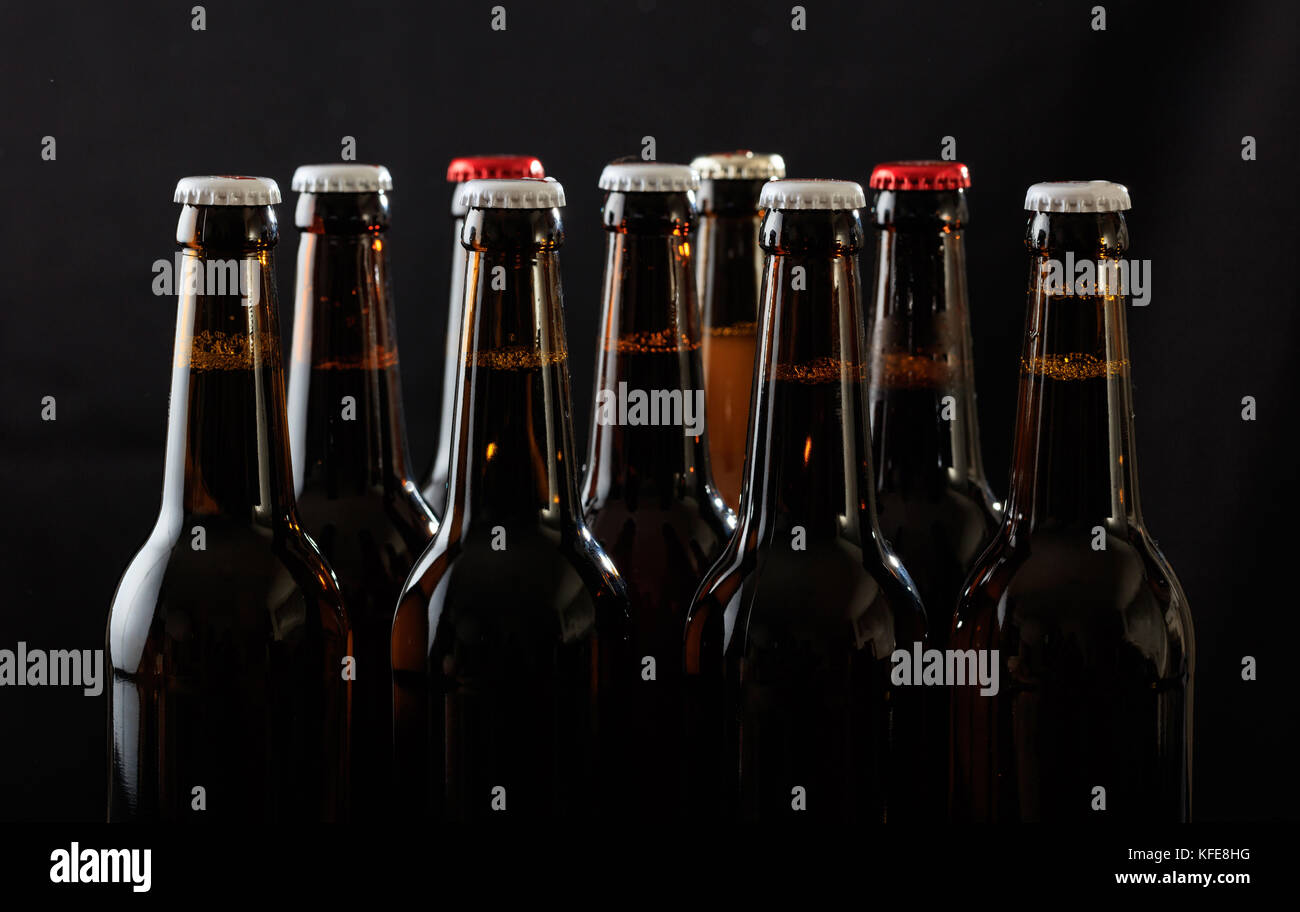 Raccolta di sigillato bottiglie di birra su sfondo nero Foto Stock