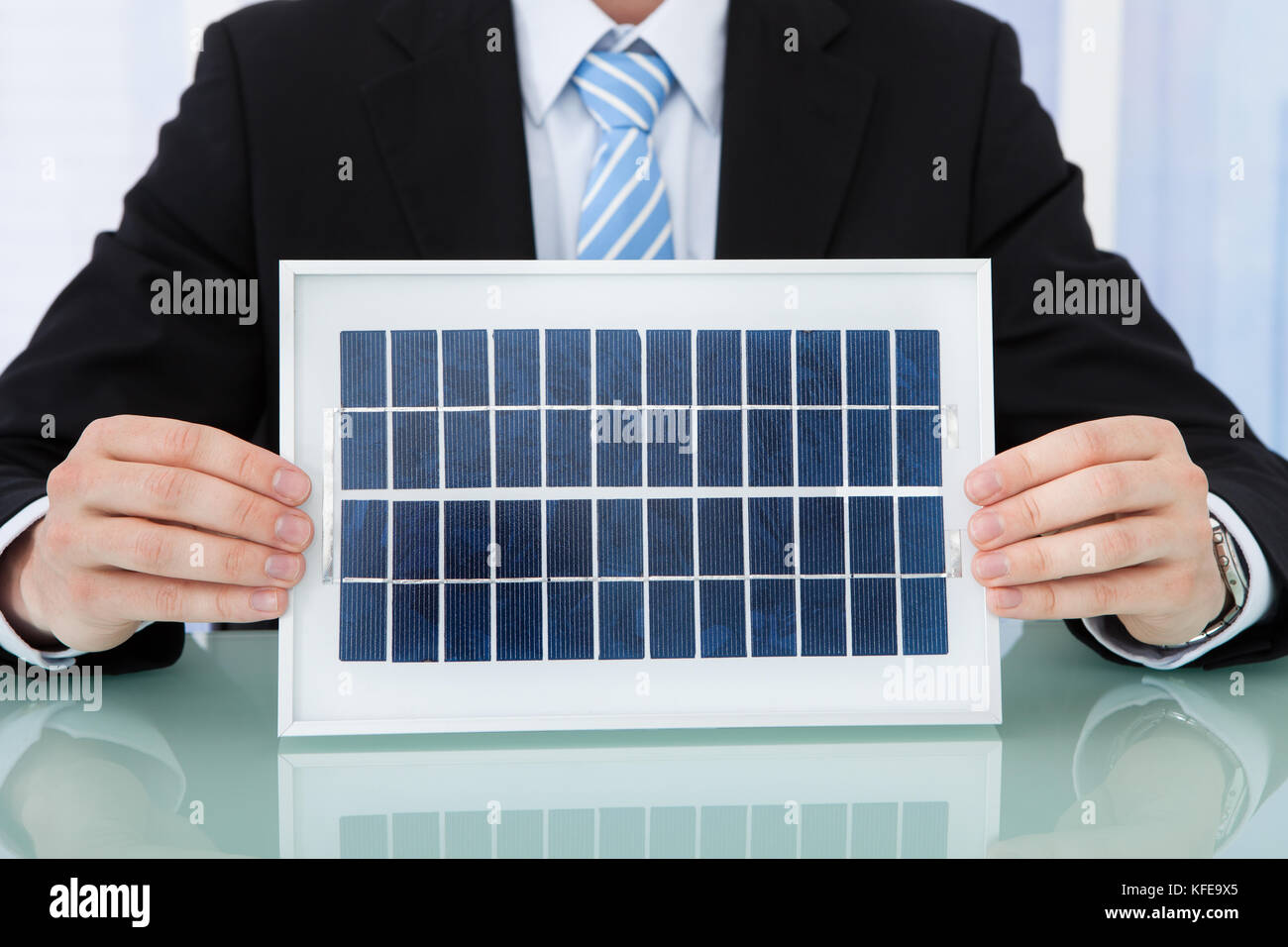 Sezione mediana di imprenditore di contenimento del pannello solare a scrivania da ufficio Foto Stock