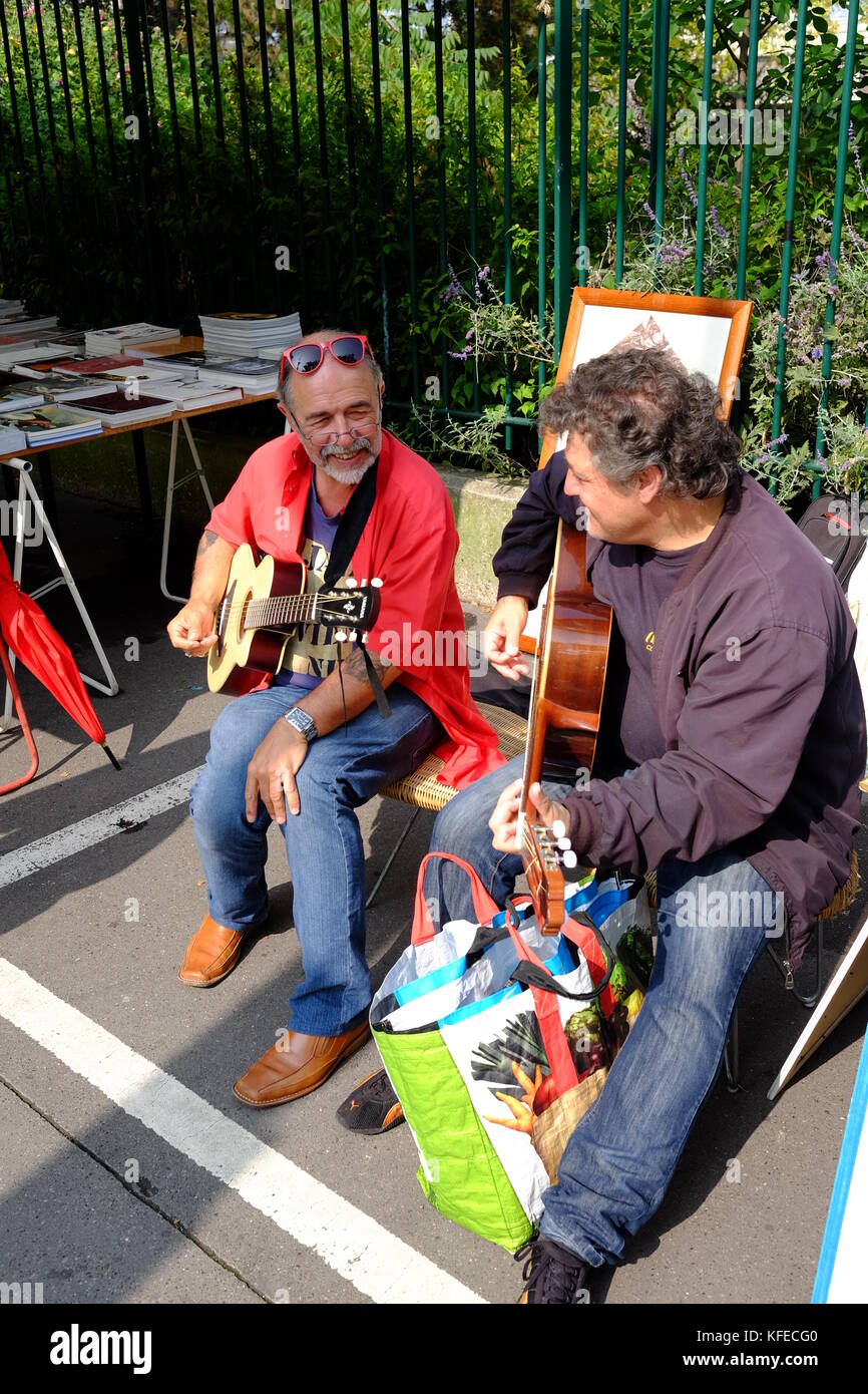 2 titolari di stallo suonare la chitarra al Marche aux Puces mercato delle pulci di Porte de Vanves a Parigi in una Domenica mattina Foto Stock