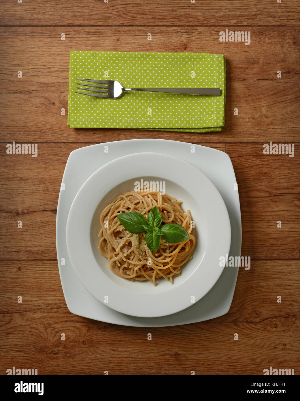 Tutto il frumento spaghetti con parmigiano e foglia di basilico - primo piano Foto Stock